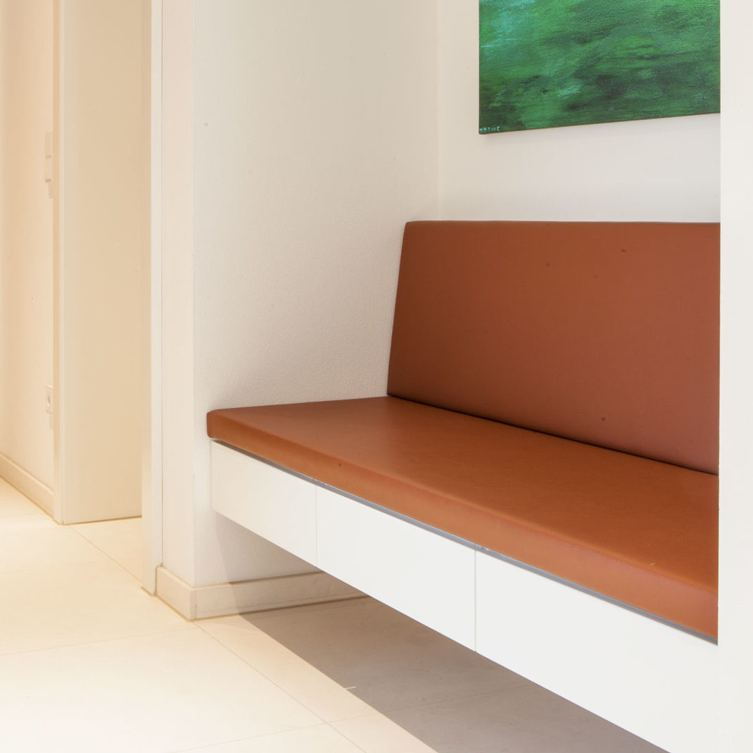 Garderobe mit lederbezogener Sitzbank, weißen Möbel und Nische in Eiche