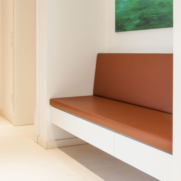 Garderobe mit lederbezogener Sitzbank, weißen Möbel und Nische in Eiche