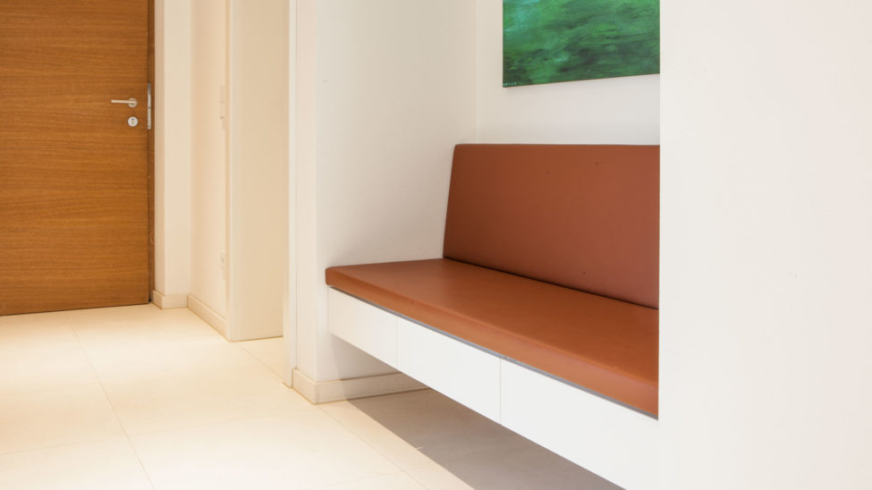 Garderobe mit lederbezogener Sitzbank, weißen Möbel und Nische in Eiche