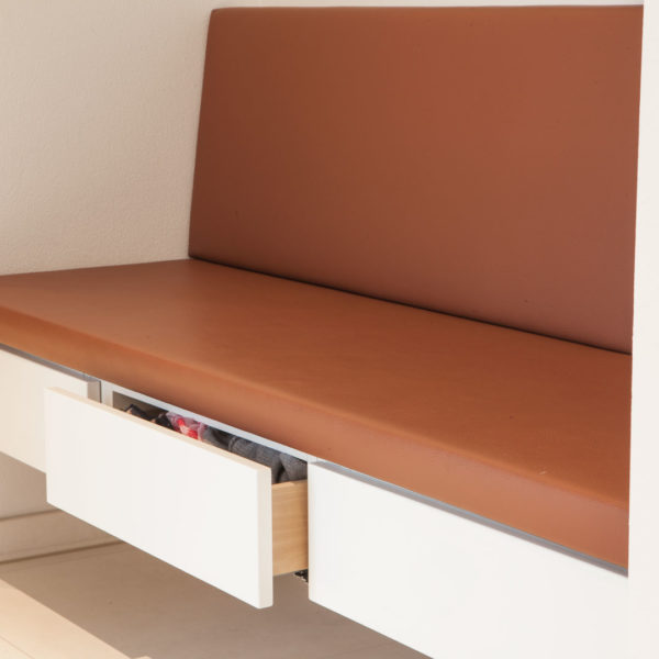 Garderobe mit lederbezogener Sitzbank, weißen Möbel und Nische in Eiche