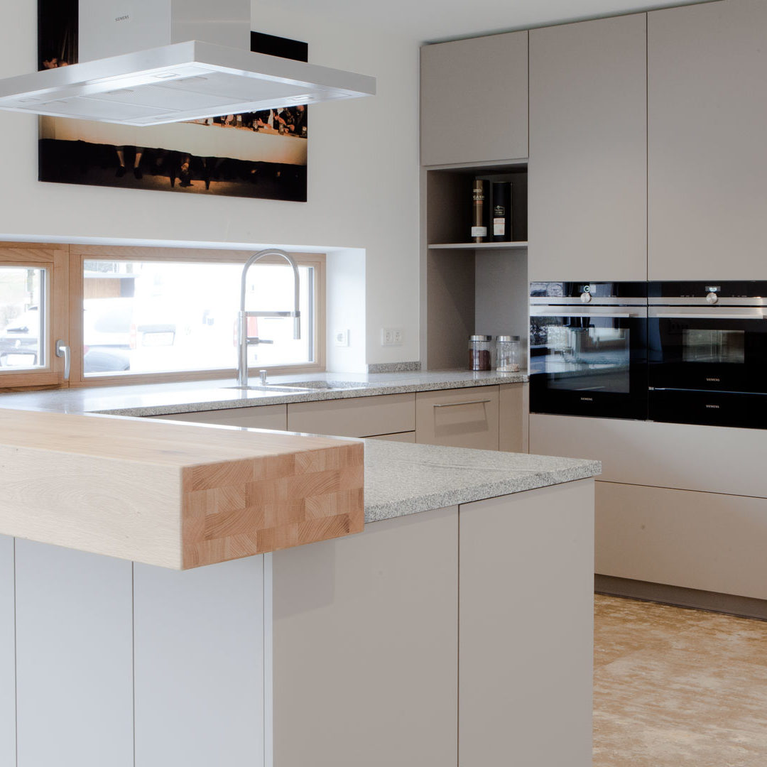 Küche in grau mit Frühstückstresen aus massivem Holz