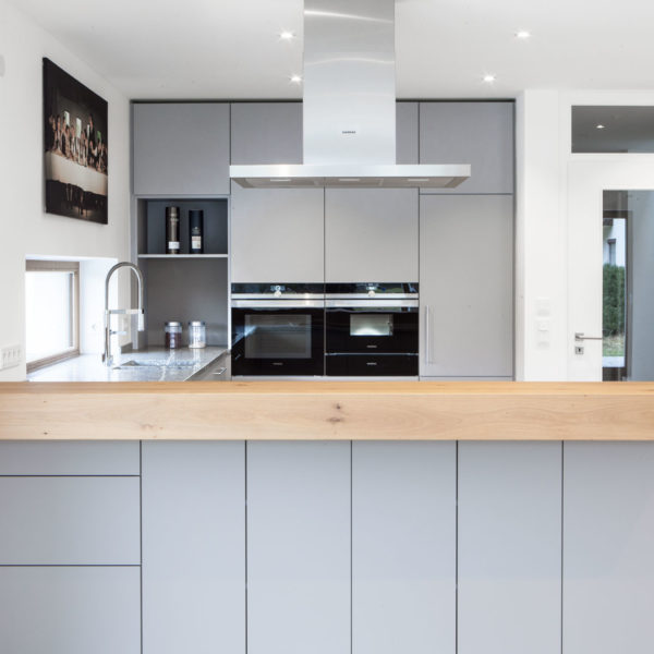 Küche in grau mit Frühstückstresen aus massivem Holz