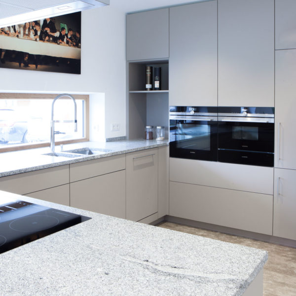 Küche in grau mit Frühstückstresen aus massivem Holz