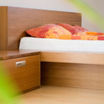 Schlafzimmer mit Wasserbett, Sideboard und Nachtkästchen