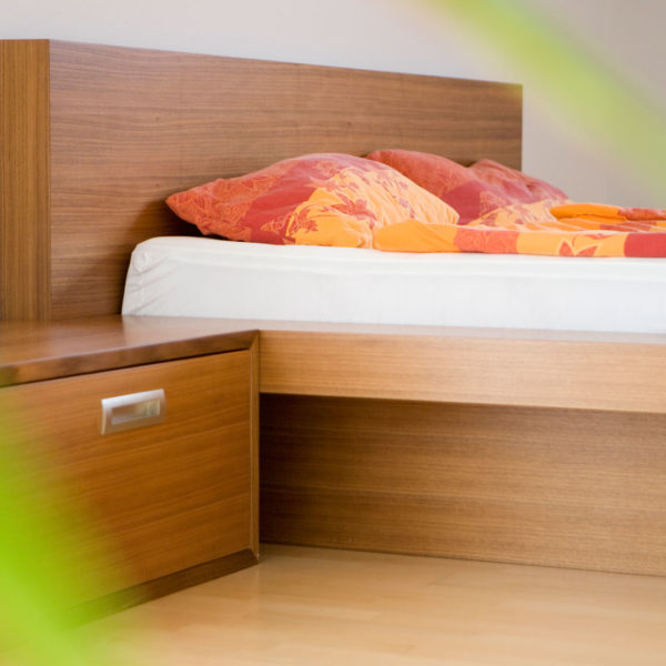 Schlafzimmer mit Wasserbett, Sideboard und Nachtkästchen