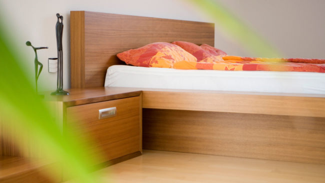 Schlafzimmer mit Wasserbett, Sideboard und Nachtkästchen