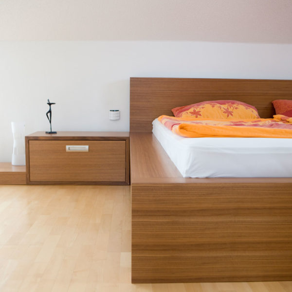 Schlafzimmer mit Wasserbett, Sideboard und Nachtkästchen