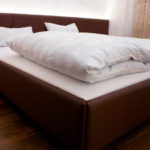 Bett gepolstert und mit Leder überzogen