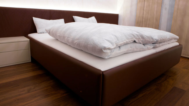 Bett gepolstert und mit Leder überzogen