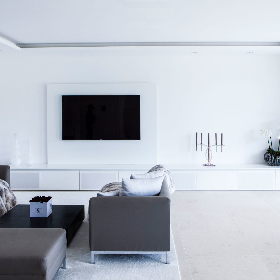 Wohnzimmer in weiß mit großem TV-Schrank und integriertem Soundsystem
