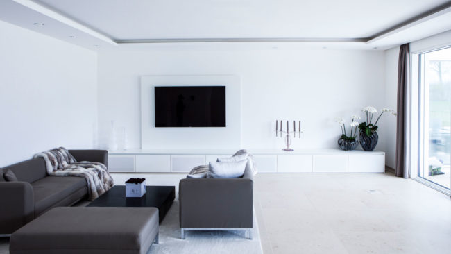 Wohnzimmer in weiß mit großem TV-Schrank und integriertem Soundsystem
