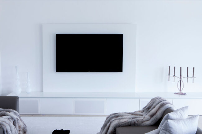 Wohnzimmer in weiß mit großem TV-Schrank und integriertem Soundsystem