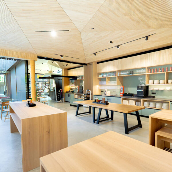 Modern gestalteter Thekenbereich mit offenen Regalen, Selbstbedienungstheke und viel Tageslicht in einer Café- oder Restaurantumgebung.