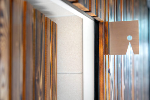 Design-Toilettenschild für Herren auf rustikaler Holzverkleidung in Nahaufnahme.