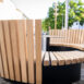 Moderne Rundbank aus Holz mit vertikalen Lamellen.